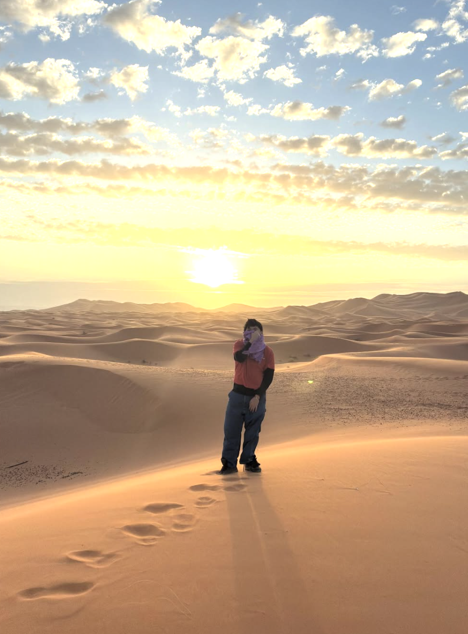 Me standing on sand dunes in the Sahara sunrise